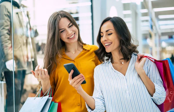 Hermosas Amigas Jóvenes Felices Emocionadas Con Bolsas Papel Teléfono Inteligente — Foto de Stock