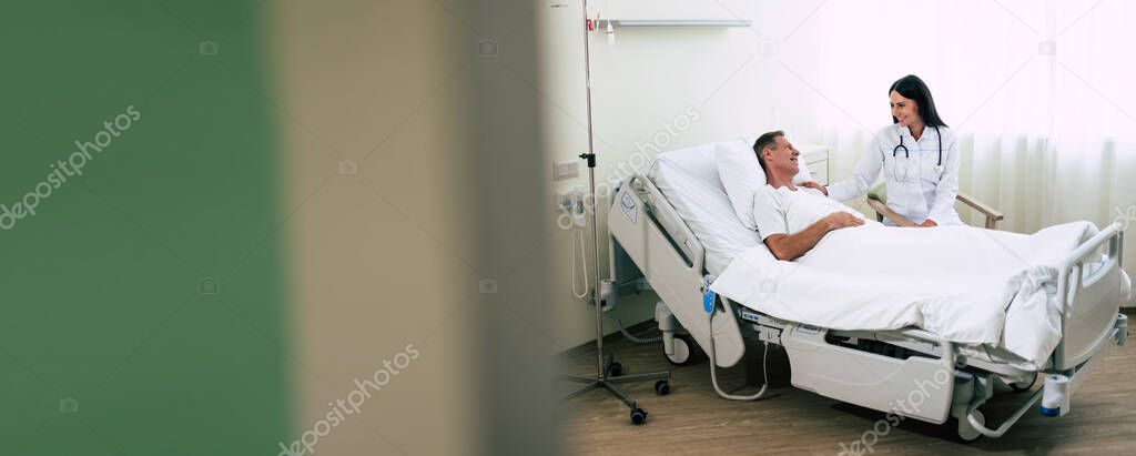 Happy confident woman doctor with a stethoscope is talking with man patient in the hospital ward