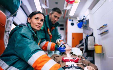Doktorların acil durumu ya da sağlık görevlileri, yaşlı bir hastayla ambulansta sedyede yatarken birlikte çalışıyorlar..