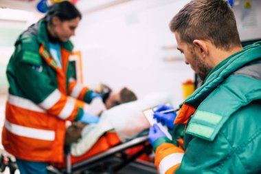 Doktorların acil durumu ya da sağlık görevlileri, yaşlı bir hastayla ambulansta sedyede yatarken birlikte çalışıyorlar..
