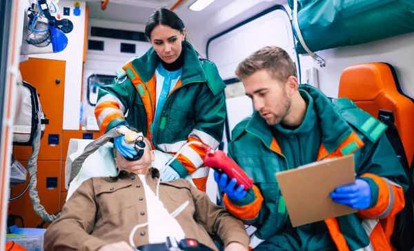 Doktorların Acil Durumu Sağlık Görevlileri Yaşlı Bir Hastayla Ambulansta Sedyede — Stok fotoğraf