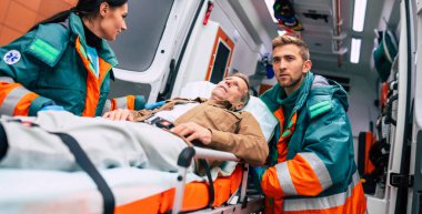 Ambulanstaki ciddi ve profesyonel doktorlar acil bir durum sırasında bir hastayı hastaneye götürüyorlar..