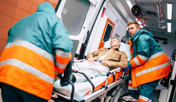 Ambulanstaki ciddi ve profesyonel doktorlar acil bir durum sırasında bir hastayı hastaneye götürüyorlar..