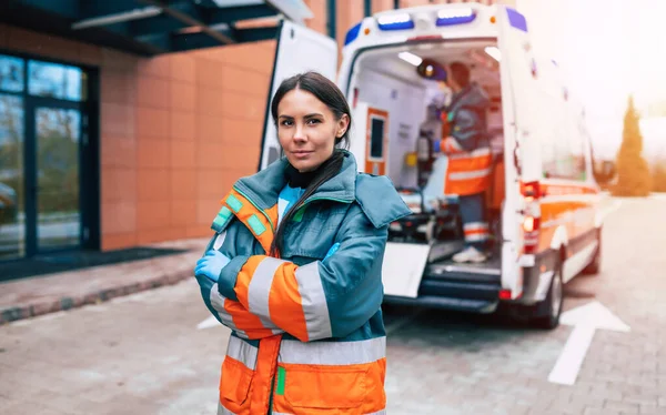 Professionell Och Självsäker Ung Kvinna Läkare Tittar Kameran Med Ambulans — Stockfoto