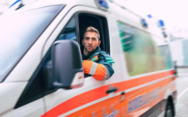 Professionele Zelfverzekerde Jongeman Arts Zoek Naar Camera Met Ambulance Achtergrond — Stockfoto