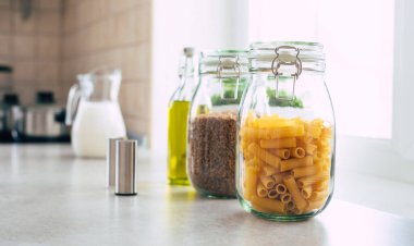 Kavanozlarda yemek pişirmek için gerekli malzemeler mutfak masasında duruyor.