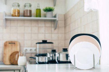 Tabakları masada, tavaları ocakta olan modern, güzel bir mutfak.