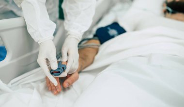 Coronavirus covid-19 hastanedeki bir karantina koğuşunda, onu tedavi ederken koruyucu giysiler giyen doktorlarla birlikte.