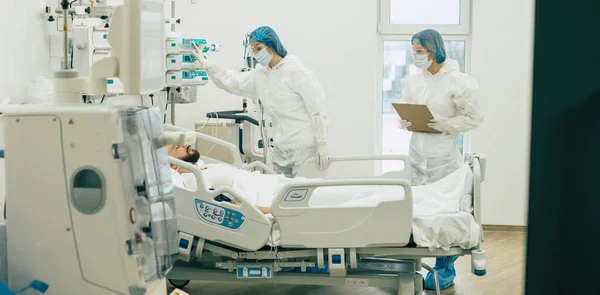 Koruyucu Giysili Maskeli Doktorlar Hastane Koğuşundaki Hasta Koronavirüsünü Inceliyor — Stok fotoğraf