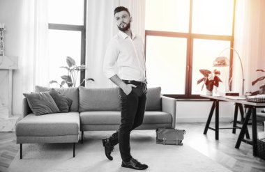 Şık ve mutlu modern iş adamı yeni açılan ofiste şık giyinmiş poz veriyor.