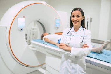 Modern bir hastanenin manyetik rezonans görüntüleme ya da bilgisayarlı tomografi odasında kendinden emin kadın doktor onkolojisi.