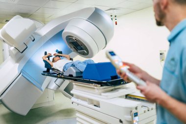 Modern bir tıbbi klinikte ya da doğrusal hızlandırıcısı olan bir hastanede kanser tedavisi. Kadın kanser için radyasyon tedavisi görürken profesyonel doktor ekibi çalışıyor.