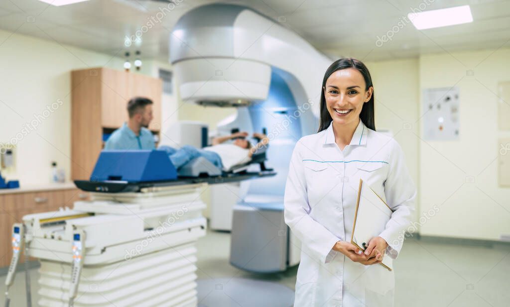 Cancer treatment in a modern medical private clinic or hospital with a linear accelerator. Professional doctors team working while the woman is undergoing radiation therapy for cancer