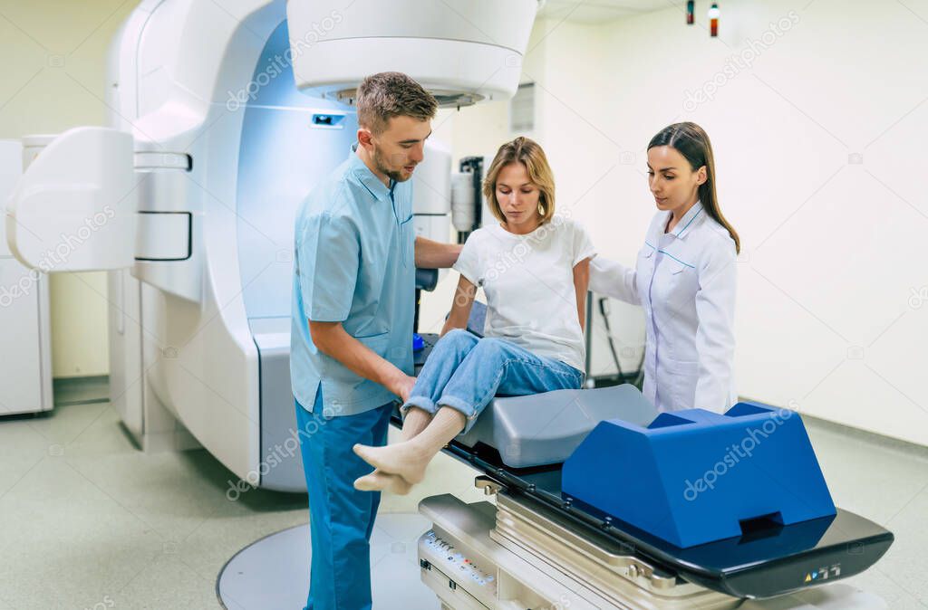 Cancer treatment in a modern medical private clinic or hospital with a linear accelerator. Professional doctors team working while the woman is undergoing radiation therapy for cancer