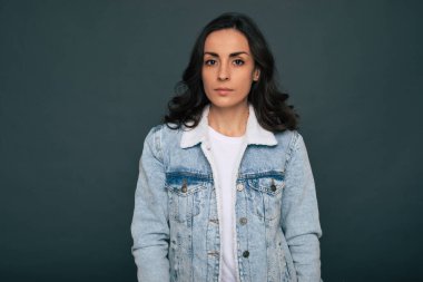 Modern modaya uygun şık, güzel esmer kadın gri arka planda poz veriyor.