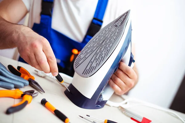 Close Photo Concentrated Young Man While Fixing Damaged Iron His — Fotografia de Stock