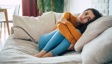 Derin depresyondaki üzgün kadın kanepede oturup ağlıyor ve kötü şeyleri düşünüyor.