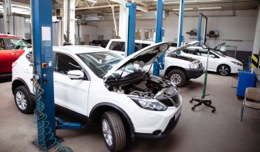 Tamir sürecinde bir benzin istasyonunda kaputu açık modern güzel bir araba.