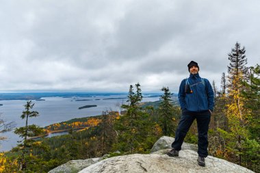 Finlandiya 'da Kayalıklara Bakan Kayalık Kayalıklarda Duran Yürüyüşçü ve Finlandiya' da Sonbahar Ormanı Macera Gezisi Koli Milli Parkı 'nda