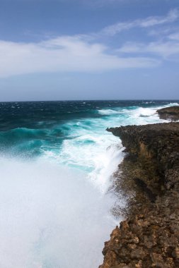 Tatilin saf hissi: güzel mavi bir deniz, sis, kayalar. Ufkun çarpıcı bir görüntüsü. Curaao adasındaki Boca Tabla Doğa Koruma Alanı