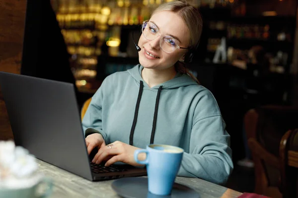 young woman in cafe with laptop