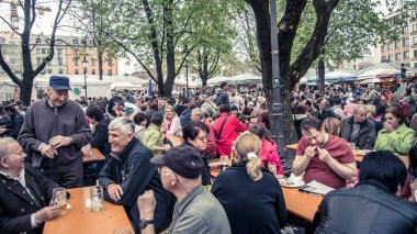 Münih, Almanya - Nisan 2014: Bira bahçesinde bira içen insanlar