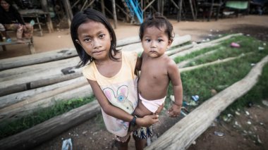 Tonle Sap Gölü, Kamboçya - Aralık 2015: Genç kız ve küçük kardeşi Tonle Sap Gölü 'nde Komprongpok' un yüzen köyünde
