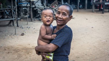 Tonle Sap Gölü, Kamboçya - Aralık 2015: Kamboçyalı kadın ve torunu Tonle Sap gölünde yüzen Komprongpok köyünde