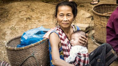 Laos - Aralık 2015: Laos kadını bebeğiyle yerel pazarda