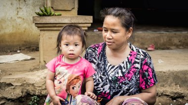 Laos - Aralık 2015: Laos kadını kızıyla birlikte yerel pazarda