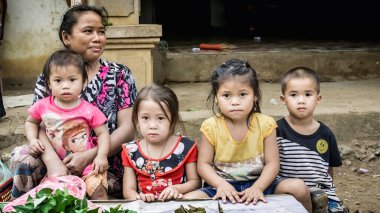 Laos - Aralık 2015: Laos kadını çocuklarıyla birlikte yerel bir pazarda