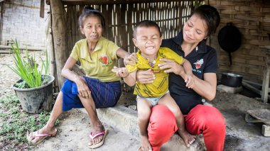 Laos - Aralık 2015: Mutlu Laos ailesi ve komik bir çocuk yerel pazarda