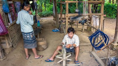 Laos - Aralık 2015: Laos kırsalında evde dokuma tezgahında çalışan çift.