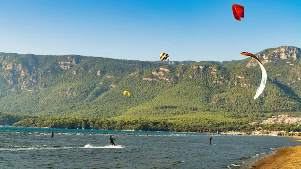 Marmaris, Akyaka, Türkiye - Kasım 2020: Marmaris 'in Akyaka ilçesinde insanlar uçurtma uçuruyor. Akyaka plajı uçurtmacılar ve uçurtma sporları için popüler bir yerdir.