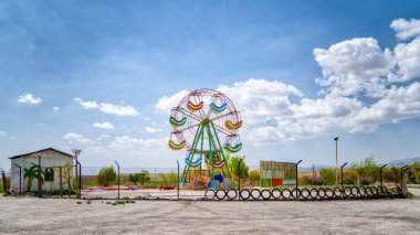 İsfahan, İran - Mayıs 2019: İran 'daki İsfahan yakınlarındaki terk edilmiş lunaparkta dönme dolap
