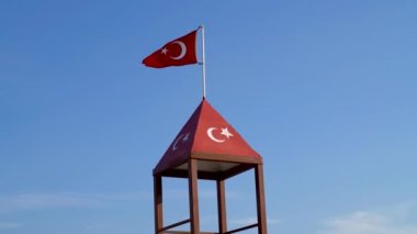 Mavi gökyüzüne dalgalanan Türk bayrağı. Türkiye bayrağı mavi gökyüzünde rüzgarda dalgalanıyor.
