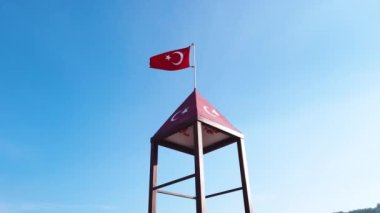 Mavi gökyüzüne dalgalanan Türk bayrağı. Türkiye bayrağı mavi gökyüzünde rüzgarda dalgalanıyor.