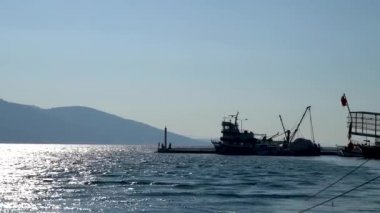 Marmaris, Akyaka, Türkiye - Kasım 2020: Akyaka köyü limanında kimliği belirsiz insanlarla dolu bir balıkçı teknesinin silüeti