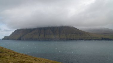 Kuzey Atlantik 'teki dağın tepesindeki Faroe Adaları' nda dramatik bir manzara. Kuzey Atlantik 'teki Faroe Adaları' nın doğası.