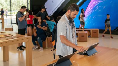 Cupertino, CA, USA - Ağustos 2019: Cupertino 'daki Apple Store' da iPad 'i inceleyen adam, Apple' ın Sonsuz Döngü Merkezi