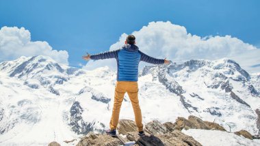 Zermatt, İsviçre - Mayıs 2017: Kayalık bir uçurumun tepesinde duran adam. Başarı kavramı.