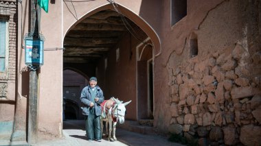 Abyaneh, İran - Mayıs 2019: Yaşlı adam ve eşeği geleneksel Abyaneh köyünde