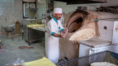 Abyaneh, İran - Mayıs 2019: Geleneksel fırında ekmek yapan adam