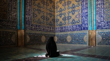 İsfahan, İran - Mayıs 2019: Siyah elbiseli İranlı kadın Naqsh-e Cihan Meydanı 'ndaki Şeyh Lotfollah Camii' nde dua ediyor
