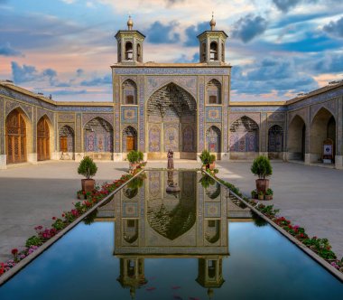 Şii, İran - Mayıs 2019: Günbatımında Nasir al-Mulk Camii 'nin yanında duran İranlı kadın. Nasir Al-Mulk Camii, Pembe Cami olarak da bilinir..