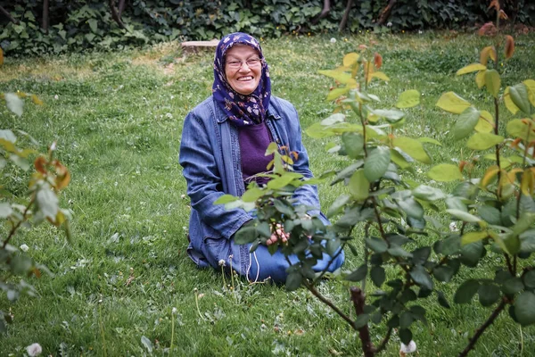 Mulher Muçulmana Sênior Parque Público Sentado Sobre Grama Por Plantas — Fotografia de Stock