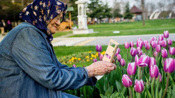 Mulher Muçulmana Sênior Tirando Uma Foto Flores Com Seu Smartphone — Fotografia de Stock