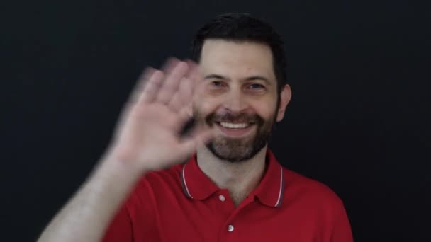 Άντρας Κουνάει Χέρι Φορώντας Ένα Κόκκινο Μπλουζάκι Απομονωμένο Μαύρο Φόντο — Αρχείο Βίντεο
