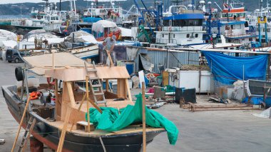 Rumeli Feneri, İstanbul, Türkiye - Ağustos 2021: Sariyer ilçesindeki Rumeli Feneri limanında balıkçı teknesi tamir eden adam.