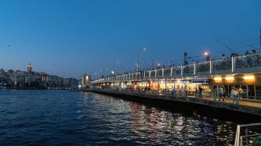 İstanbul, Türkiye - Eylül 2021: Restoranlar ve insanlarla dolu Galata Köprüsü. Galata Köprüsü, İstanbul 'un eski Eminonu kentinde popüler bir turistik merkezdir..